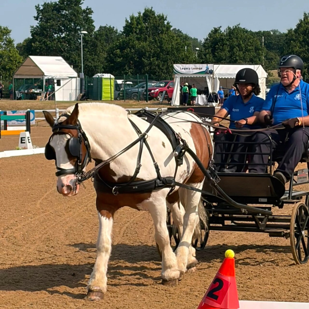 Lauryn Miller and Peter Tomlin dressed in blue riding in their carriage at the PDA National Championships.