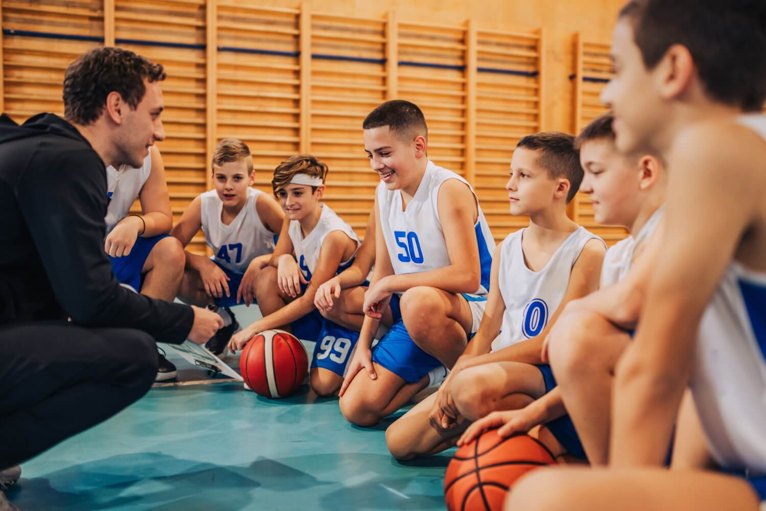 Coach talking to a group of young partiicpants in a school sport session