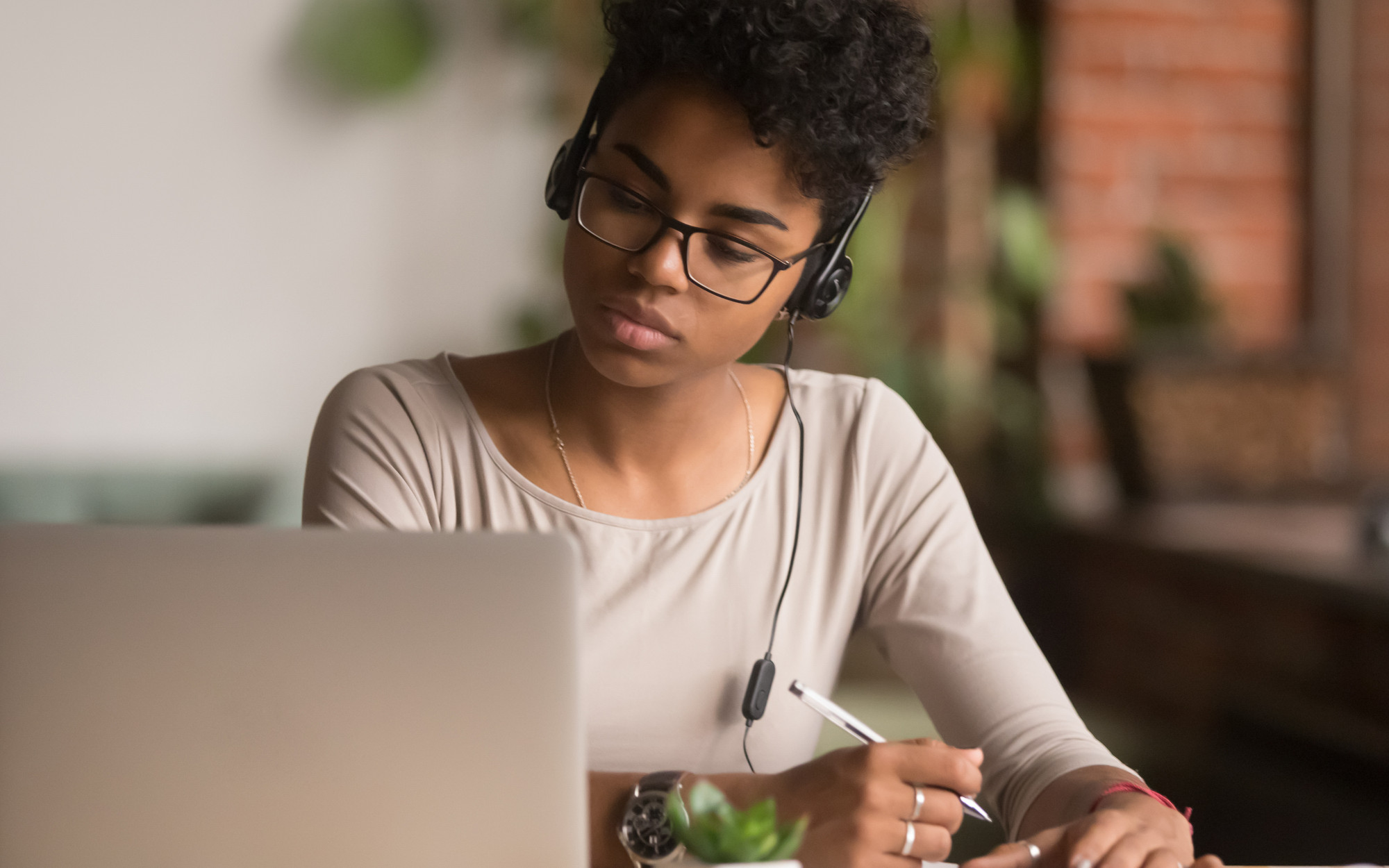 female-writing-on-notepad-at-laptop-v2