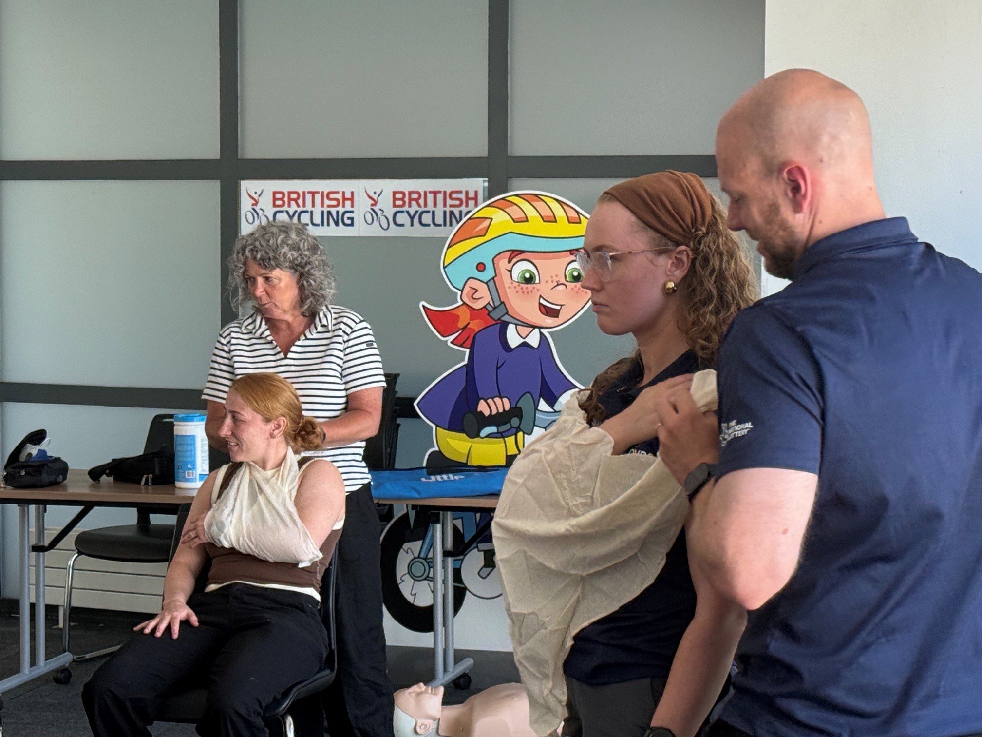 Participants practise applying arm slings during a UK Coaching First Aid workshop for British Cycling staff and volunteers.