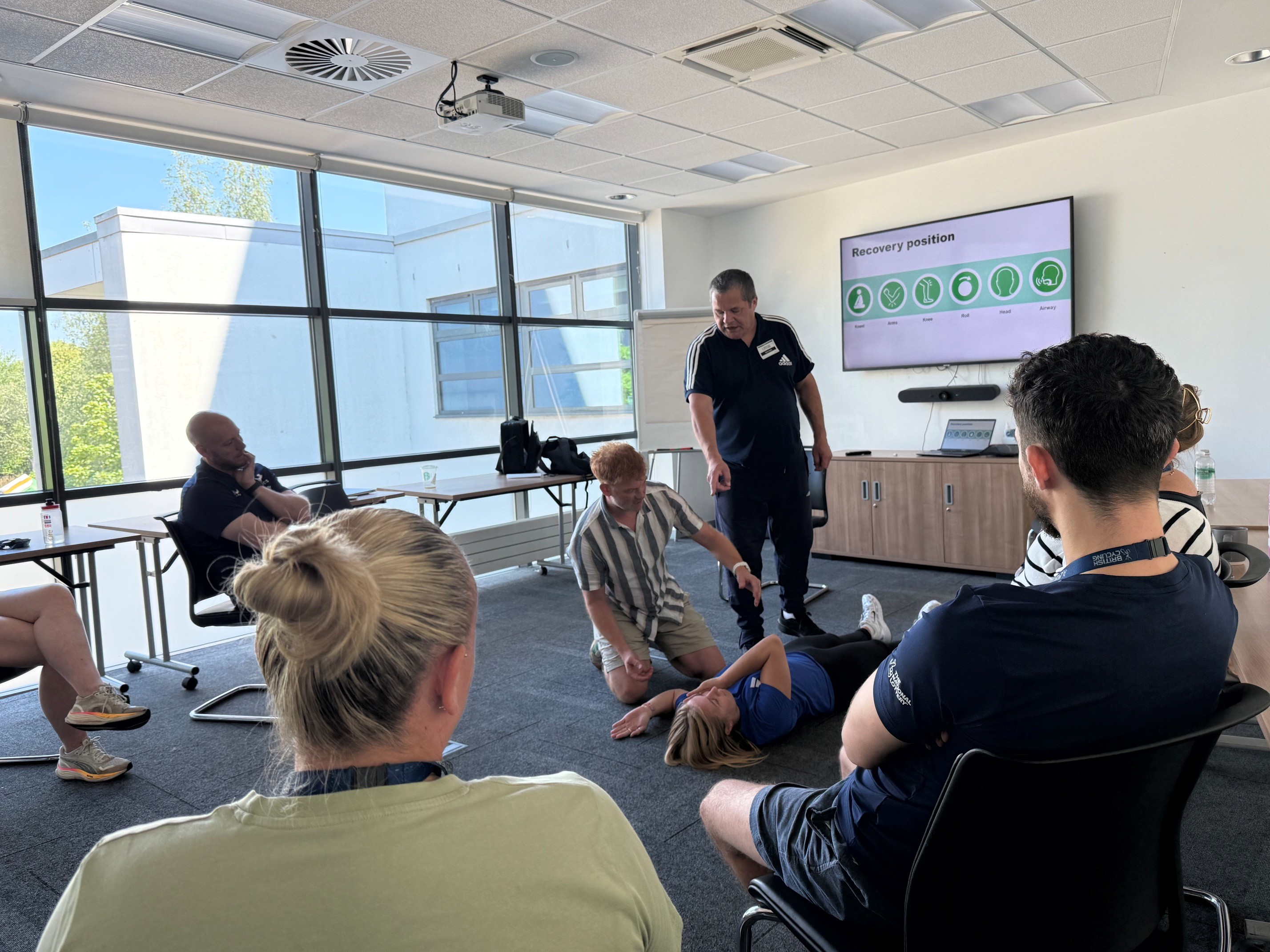 UK Coaching tutor leads a practical recovery position demonstration as participants take part in First Aid training at British Cycling's National Cycling Centre.